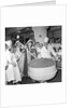 Cliff Richard mixing a giant Christmas pudding at J.Lyons in Cadby Hall, Hammersmith by Harry Hammond
