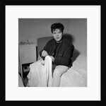 Cliff Richard in his first house sitting on a bed by Harry Hammond