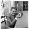 Liberace seated at the piano at the Savoy Hotel by Harry Hammond