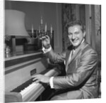 Liberace playing the piano at the Savoy Hotel by Harry Hammond