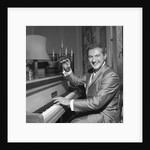 Liberace playing the piano at the Savoy Hotel by Harry Hammond