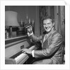 Liberace playing the piano at the Savoy Hotel by Harry Hammond