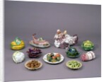 Arrangement of ceramic tureens and trick plates in the shape of vegetables and other food by Unknown