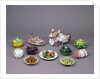 Arrangement of ceramic tureens and trick plates in the shape of vegetables and other food by Unknown