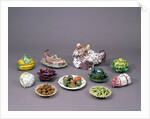 Arrangement of ceramic tureens and trick plates in the shape of vegetables and other food by Unknown