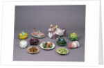 Arrangement of ceramic tureens and trick plates in the shape of vegetables and other food by Unknown
