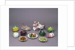 Arrangement of ceramic tureens and trick plates in the shape of vegetables and other food by Unknown