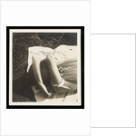 Woman wearing striped t-shirt lying on rug with both arms covering face by Curtis Moffat